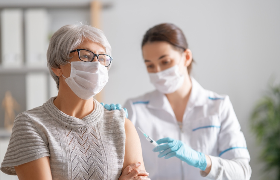 Elderly woman getting a vaccine.